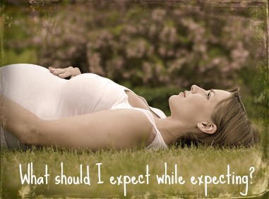 Beautiful pregnant woman relaxing on grass