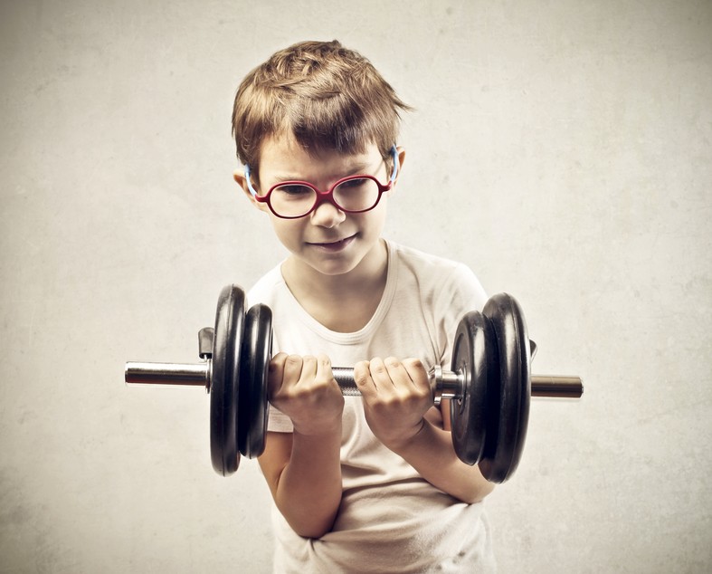 Little boy with classes lifting a dumbbell